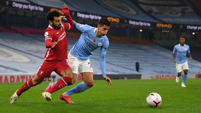 MANCHESTER, ENGLAND - NOVEMBER 08: Mohamed Salah of Liverpool is challenged by Joao Cancelo of Manchester City during the Premier League match between Manchester City and Liverpool at Etihad Stadium on November 08, 2020 in Manchester, England. Sporting stadiums around the UK remain under strict restrictions due to the Coronavirus Pandemic as Government social distancing laws prohibit fans inside venues resulting in games being played behind closed doors. (Photo by Shaun Botterill/Getty Images)
