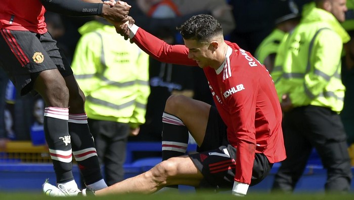 Manchester Uniteds Paul Pogba helps teammate Cristiano Ronaldo get back on his feet at the end of the Premier League soccer match between Everton and Manchester United at Goodison Park, in Liverpool, England, Saturday, April 9, 2022. Everton won 1-0. (AP Photo/Rui Vieira)