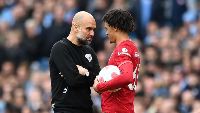 MANCHESTER, ENGLAND - APRIL 10: Trent Alexander-Arnold of Liverpool and Pep Guardiola, Manager of Manchester City share a joke during the Premier League match between Manchester City and Liverpool at Etihad Stadium on April 10, 2022 in Manchester, England. (Photo by Michael Regan/Getty Images)