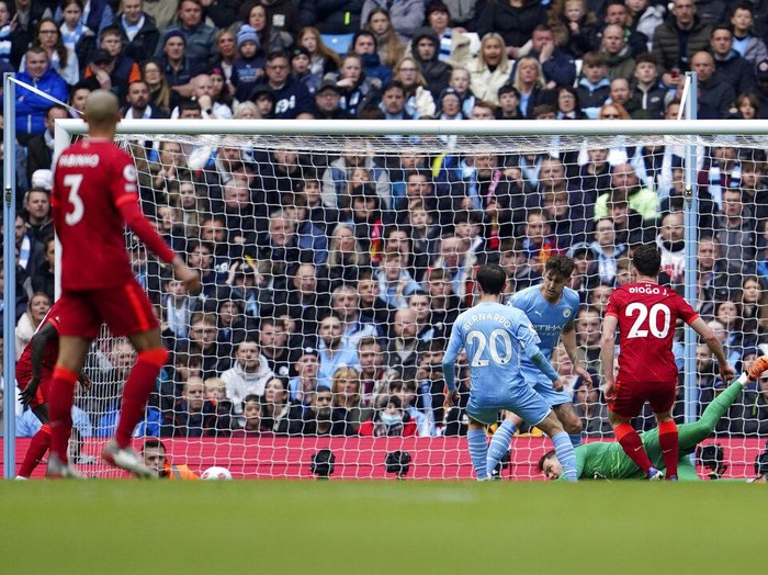 Manchester City's Kevin De Bruyne, centre, celebrates after scoring the opening goal of the game during the English Premier League soccer match between Manchester City and Liverpool, in Manchester, England, Sunday, April 10, 2022. (AP Photo/Jon Super)