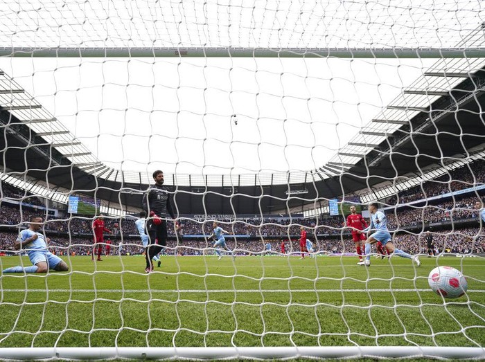 Manchester City's Kevin De Bruyne, centre, celebrates after scoring the opening goal of the game during the English Premier League soccer match between Manchester City and Liverpool, in Manchester, England, Sunday, April 10, 2022. (AP Photo/Jon Super)