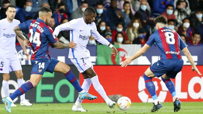 Barcelona's Ousmane Dembele vies for the ball with Levante's Ruben Vezo and Pepelu, right, during a Spanish La Liga soccer match between Levante and Barcelona at the Ciutat de Valencia stadium in Valencia, Spain, Sunday, April 10, 2022. (AP Photo/Alberto Saiz)