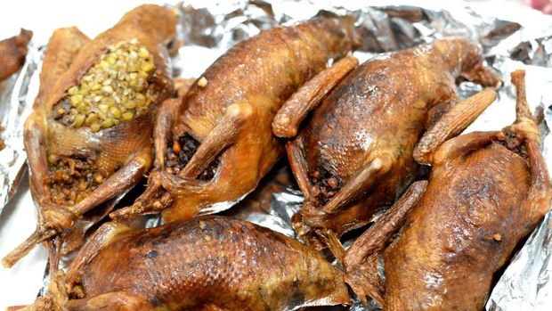 Egyptian Hamam Mahshi or stuffed squab, An Arabic cuisine, Egyptian traditional stuffed pigeon dish filled with rice and Freekeh which is a cracked green wheat grains, oriental roasted pigeons meal