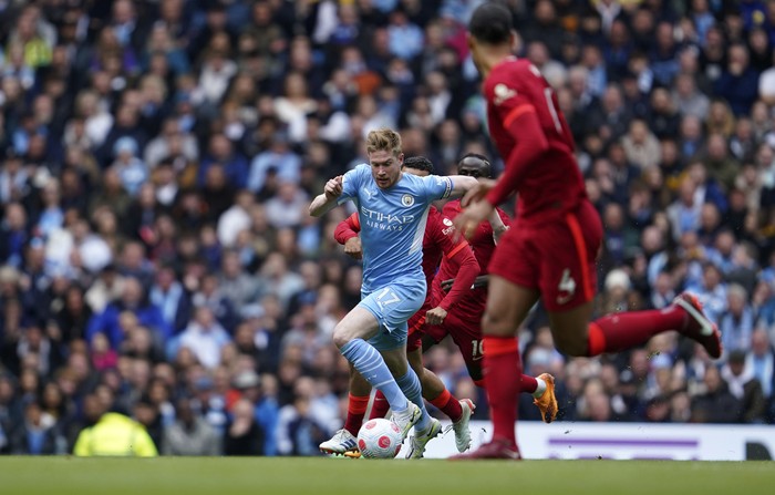 Manchester Citys Kevin De Bruyne, center, controls the ball during the English Premier League soccer match between Manchester City and Liverpool, at the Etihad stadium in Manchester, England, Sunday, April 10, 2022. (AP Photo/Jon Super)