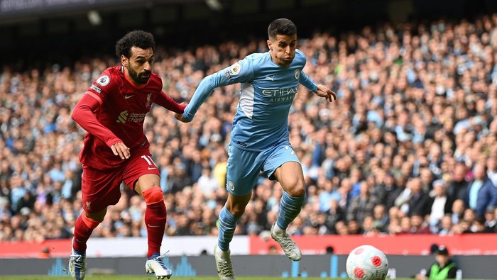 MANCHESTER, ENGLAND - APRIL 10: Joao Cancelo of Manchester City is challenged by Mohamed Salah of Liverpool during the Premier League match between Manchester City and Liverpool at Etihad Stadium on April 10, 2022 in Manchester, England. (Photo by Shaun Botterill/Getty Images)