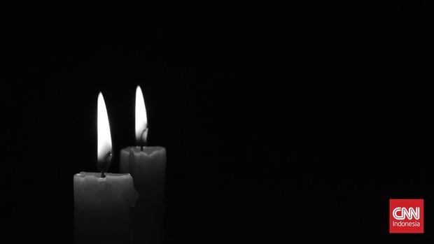 Light candle burning brightly in the black background. Candle flame. Black and white photo. There's room for your text. The concept of mourning, grief or sorrow.