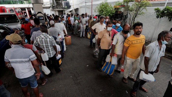 A man sits on a domestic gas cylinder as he waits in line to buy gas on a main road, amid the countrys economic crisis in Colombo, Sri Lanka, April 12, 2022. REUTERS/Dinuka Liyanawatte