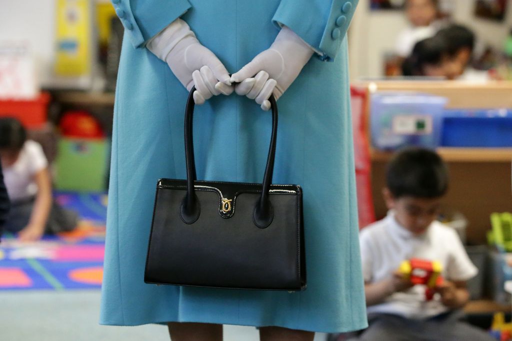 LONDON, ENGLAND - JUNE 15:  Britain's Queen Elizabeth II holds her handbag as she tours the classrooms at Mayflower Primary School during a visit to Poplar in Tower Hamlets on June 15, 2017 in London, England.  The visit coincides with commemorations for the centenary of the bombing of Upper North Street School during the First World War.  (Photo by Daniel Leal-Olivas/WPA Pool/Getty Images)