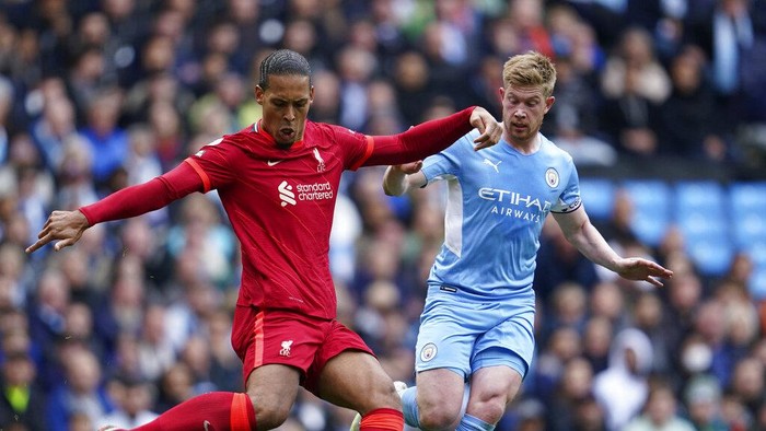 Liverpools Virgil van Dijk, left, duels for the ball with Manchester Citys Kevin De Bruyne during the English Premier League soccer match between Manchester City and Liverpool, at the Etihad stadium in Manchester, England, Sunday, April 10, 2022. (AP Photo/Jon Super)