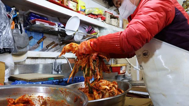 Choi Sun-hwa makes a traditional Korean side dish kimchi at her side dish store at a traditional market in Seoul, South Korea, April 7, 2022. Picture taken April 7, 2022. REUTERS/Kim Hong-Ji