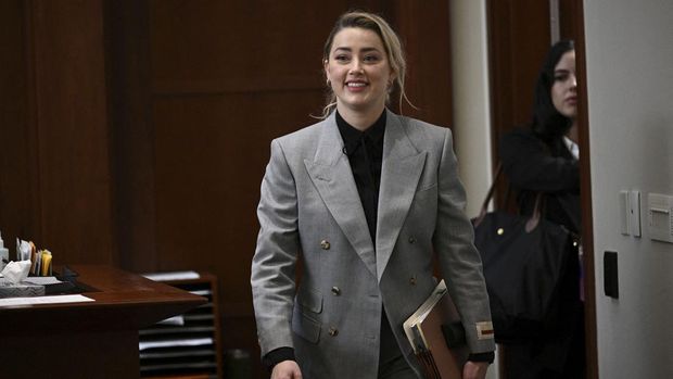 Sidang Kasus Pencemaran Nama Baik Johnny Depp Actor Amber Heard walks inside the courtroom during the Johnny Depp vs Heard defamation case at Fairfax County Circuit Court, Virginia, U.S., April 12, 2022. Brendan Smialowski/Pool via REUTERS
