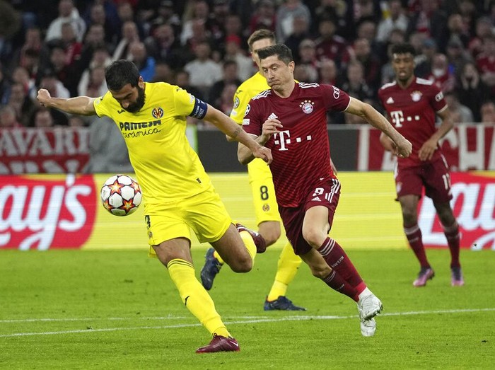 Villarreal's Francis Coquelin, right, and Bayern's Leroy Sane jump for the ball during the Champions League, second leg, quarterfinal soccer match between Bayern Munich and Villareal at the Allianz Arena, in Munich, Germany, Tuesday, April 12, 2022. (AP Photo/Matthias Schrader)