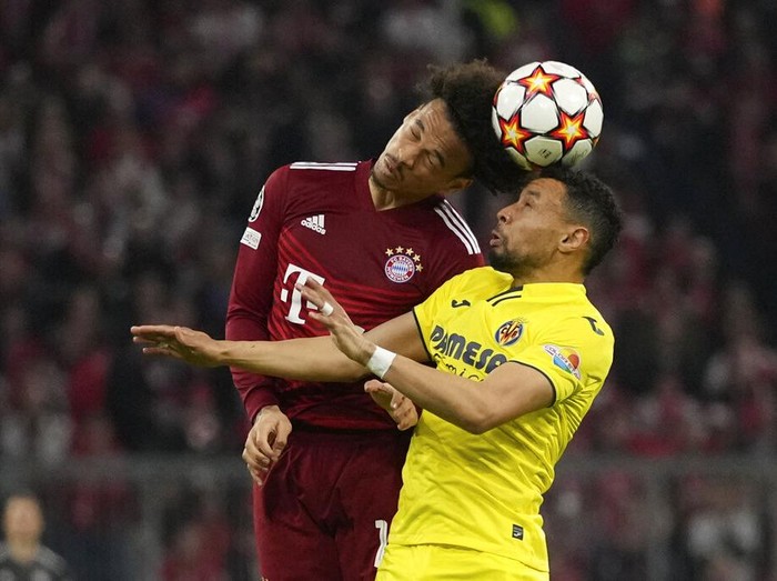 Villarreal's Francis Coquelin, right, and Bayern's Leroy Sane jump for the ball during the Champions League, second leg, quarterfinal soccer match between Bayern Munich and Villareal at the Allianz Arena, in Munich, Germany, Tuesday, April 12, 2022. (AP Photo/Matthias Schrader)