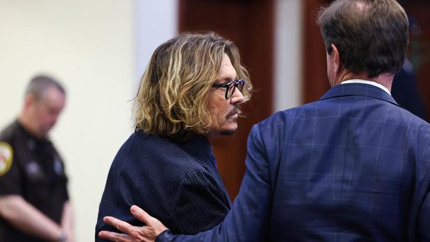 Johnny Depp di Persidangan US actor Johnny Depp walks with his attorney Ben Chew as he attends his defamation trial against his ex-wife Amber Heard at the Fairfax County Circuit Courthouse in Fairfax, Virginia, on April 13, 2022. - Heard is being sued for defamation by her former husband, US actor Johnny Depp, after she wrote an op-ed in The Washington Post in 2018 that, without naming Depp, accused him of domestic abuse. (Photo by EVELYN HOCKSTEIN / POOL / AFP)