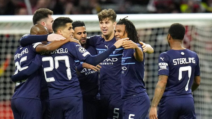 Manchester Citys Rodrigo, left, and Manchester Citys Aymeric Laporte, right, challenge Atletico Madrids Joao Felix during the Champions League quarterfinal second leg soccer match between Atletico Madrid and Manchester City at Wanda Metropolitano stadium in Madrid, Spain, Wednesday, April 13, 2022. (AP Photo/Manu Fernandez)