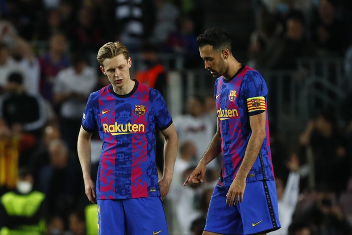Barcelona's Sergio Busquets, right, and Barcelona's Frenkie de Jong gesture as Frankfurt's Filip Kostic scores his side's third goal during the Europa League, second leg, quarterfinal soccer match between Barcelona and Eintracht Frankfurt at the Camp Nou stadium, in Barcelona, Spain, Thursday, April 14, 2022. (AP Photo/Joan Monfort)