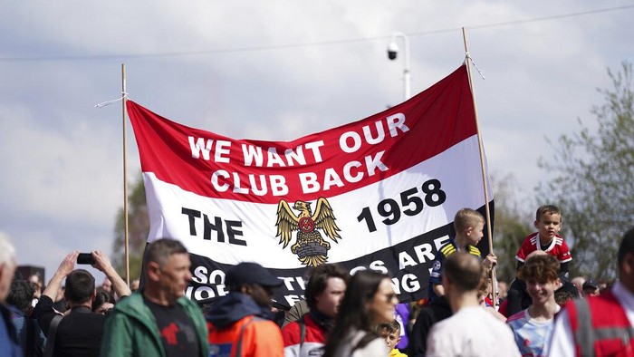 Protestors against he owners of Manchester United demonstrate before the English Premier League soccer match between Manchester United and Norwich City at Old Trafford stadium in Manchester, England, Saturday, April 16, 2022. (AP Photo/Jon Super)