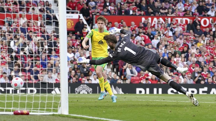 Norwich Citys Kieran Dowell, centre, scores past Manchester Uniteds goalkeeper David de Gea during the English Premier League soccer match between Manchester United and Norwich City at Old Trafford stadium in Manchester, England, Saturday, April 16, 2022. (AP Photo/Jon Super)