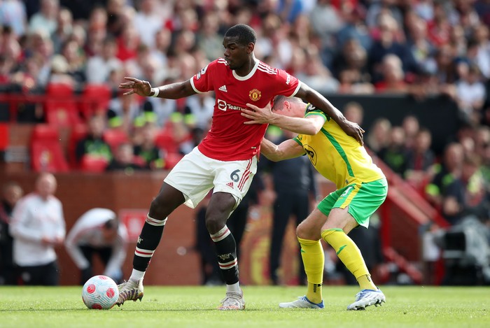 MANCHESTER, ENGLAND - APRIL 16: Paul Pogba of Manchester United is challenged by Kenny McLean of Norwich City during the Premier League match between Manchester United and Norwich City at Old Trafford on April 16, 2022 in Manchester, England. (Photo by Jan Kruger/Getty Images)