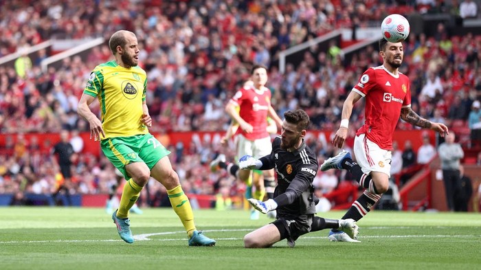 MANCHESTER, ENGLAND - APRIL 16: Teemu Pukki of Norwich City shoots and misses whilst under pressure from David De Gea of Manchester United during the Premier League match between Manchester United and Norwich City at Old Trafford on April 16, 2022 in Manchester, England. (Photo by Naomi Baker/Getty Images)