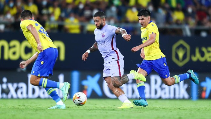 CADIZ, SPAIN - SEPTEMBER 23: Memphis Depay of FC Barcelona competes for the ball with Tomás Alarcón of Cadiz CF during the La Liga Santander match between Cadiz CF and FC Barcelona at Estadio Nuevo Mirandilla on September 23, 2021 in Cadiz, Spain. (Photo by Fran Santiago/Getty Images)