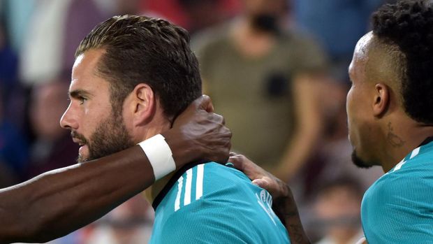 Real Madrid's Spanish defender Nacho Fernandez (L) celebrates with teammates after scoring a goal during the Spanish League football match between Sevilla FC and Real Madrid CF at the Ramon Sanchez Pizjuan stadium in Seville on April 17, 2022. (Photo by CRISTINA QUICLER / AFP)