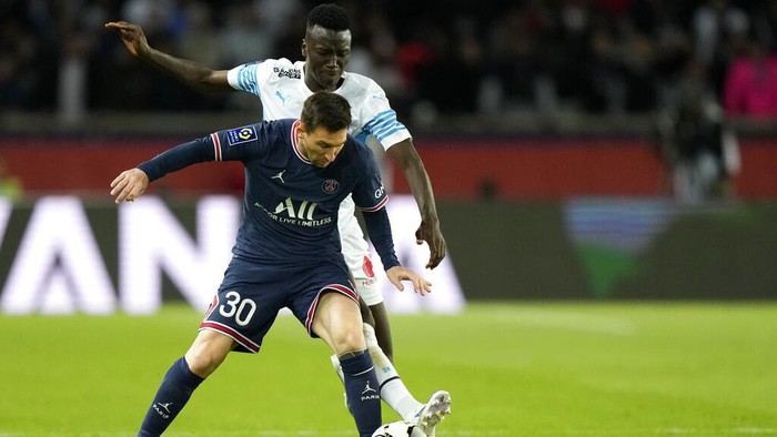 PSG's Lionel Messi, front, duels for the ball with Marseille's Pape Gueye during the League One soccer match between Paris Saint Germain and Marseille, at the Parc des Princes stadium, in Paris, France, Sunday, April 17, 2022. (AP Photo/Francois Mori)