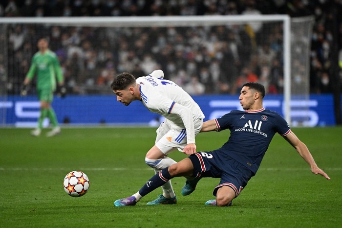 Real Madrids Uruguayan midfielder Federico Valverde (L) vies with Paris Saint-Germains Moroccan defender Achraf Hakimi during the UEFA Champions League round of 16 second league football match between Real Madrid CF and Paris Saint-Germain at the Santiago Bernabeu stadium in Madrid on March 9, 2022. (Photo by GABRIEL BOUYS / AFP)