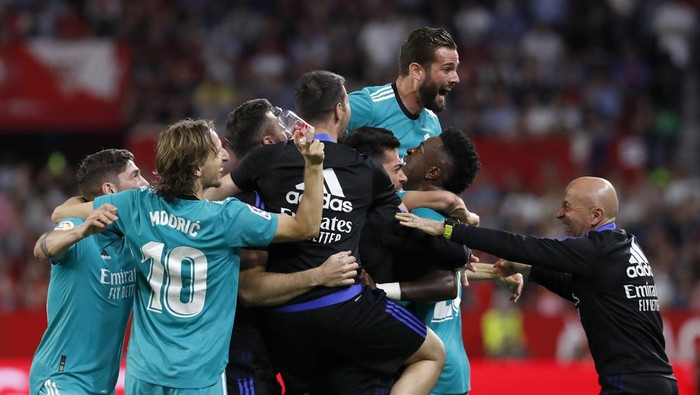 Real Madrids Karim Benzema celebrates with teammates after scoring his sides third goal during a Spanish La Liga soccer match between Sevilla and Real Madrid at the Ramon Sanchez Pizjuan stadium, in Seville, Spain, Sunday, April 17, 2022. (AP Photo/Angel Fernandez)
