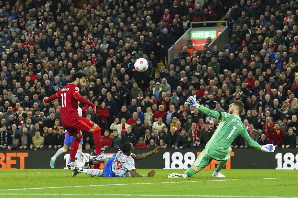 Liverpool's Mohamed Salah, left, scores his side's fourth goal during the English Premier League soccer match between Liverpool and Manchester United at Anfield stadium in Liverpool, England, Tuesday, April 19, 2022. (AP Photo/Jon Super)