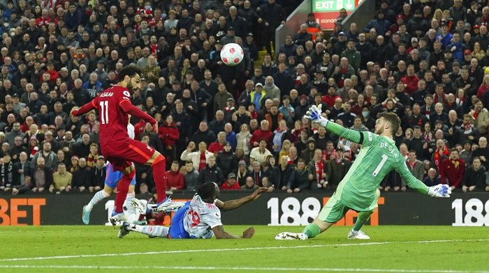 Liverpools Mohamed Salah, left, scores his sides fourth goal during the English Premier League soccer match between Liverpool and Manchester United at Anfield stadium in Liverpool, England, Tuesday, April 19, 2022. (AP Photo/Jon Super)