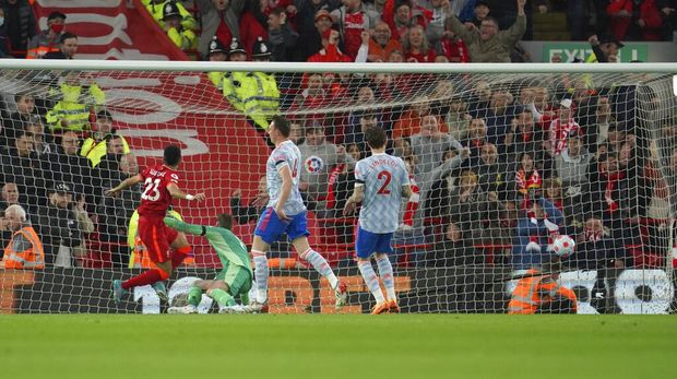 Liverpool's Luis Diaz, left, scores his side's opening goal during the English Premier League soccer match between Liverpool and Manchester United at Anfield stadium in Liverpool, England, Tuesday, April 19, 2022. (AP Photo/Jon Super)