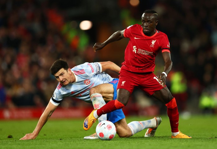 LIVERPOOL, ENGLAND - APRIL 19: Harry Maguire of Manchester United looks on as Sadio Mane of Liverpool runs with the ball during the Premier League match between Liverpool and Manchester United at Anfield on April 19, 2022 in Liverpool, England. (Photo by Clive Brunskill/Getty Images)