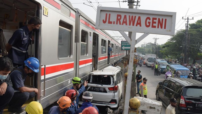 Sejumlah petugas berusaha mengevakuasi mobil Honda Mobilio yang tertabrak KRL Commuterline KA 1077 (Bogor-Jakarta Kota) di kawasan Rawageni, Ratu Jaya, Cipayung, Depok, Jabar, Rabu (20/4/2022). Kecelakaan yang terjadi di perlintasan sebidang itu menyebabkan terganggunya perjalanan KRL karena kereta harus melaju di satu jalur secara bergantian. ANTARA FOTO/Andika Wahyu/tom.