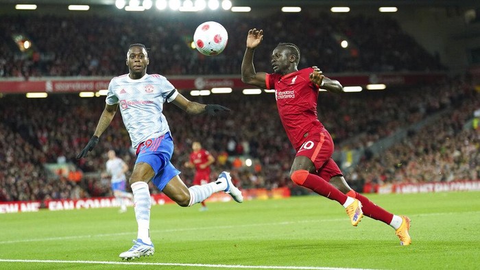 Liverpool's Sadio Mane, right, vies for the ball with Manchester United's Aaron Wan-Bissaka during the English Premier League soccer match between Liverpool and Manchester United at Anfield stadium in Liverpool, England, Tuesday, April 19, 2022. (AP Photo/Jon Super)