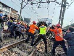 Petugas Evakuasi Mobil Tertabrak KRL di Perlintasan Citayam-Depok