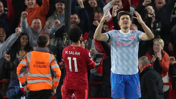 Soccer Football - Premier League - Liverpool v Manchester United - Anfield, Liverpool, Britain - April 19, 2022 Liverpool's Mohamed Salah celebrates scoring their second goal as Manchester United's Harry Maguire looks dejected