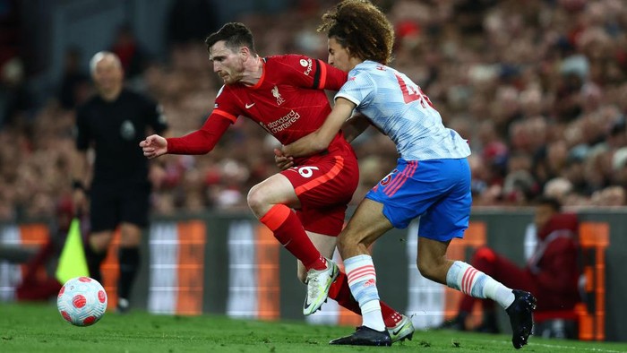 LIVERPOOL, ENGLAND - APRIL 19: Andrew Robertson of Liverpool is challenged by Hannibal Mejbri of Manchester United during the Premier League match between Liverpool and Manchester United at Anfield on April 19, 2022 in Liverpool, England. (Photo by Clive Brunskill/Getty Images)
