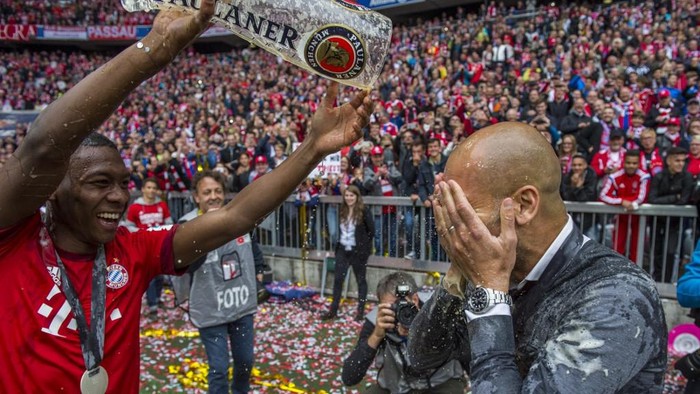 Bayern Munichs Spanish head coach Pep Guardiola (R) gets a beer shower from Bayern Munichs Austrian midfielder David Alaba as they celebrate wining their 25th Bundesliga title after German first division Bundesliga football match FC Bayern Munich vs 1 FSV Mainz 05 at the Allianz Arena in Munich, southern Germany on May 23, 2015.  AFP PHOTO / DPA / MARC MLLER   GERMANY OUT

RESTRICTIONS - DFL RULES TO LIMIT THE ONLINE USAGE DURING MATCH TIME TO 15 PICTURES PER MATCH. IMAGE SEQUENCES TO SIMULATE VIDEO IS NOT ALLOWED AT ANY TIME. FOR FURTHER QUERIES PLEASE CONTACT DFL DIRECTLY AT + 49 69 650050. (Photo by MARC MLLER / DPA / AFP)