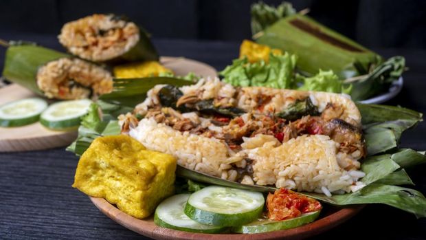 Nasi Bakar Nasi Bakar, Indonesian traditional food, filled with sliced chicken, decorated with cucumber, fried tofu, and chili sauce