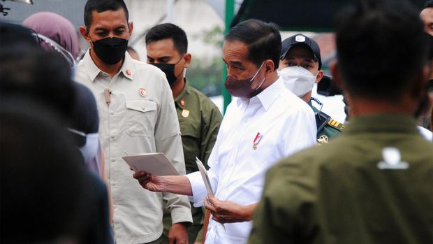 Presiden Joko Widodo berbincang dengan warga saat membagikan Bantuan Langsung Tunai (BLT) subsidi minyak goreng di Pasar Rakyat Cisarua, Kabupaten Bogor, Jawa Barat, Kamis (21/4/2022). Presiden membagikan uang tunai BLT minyak goreng sebesar Rp300 ribu, bantuan modal usaha sebesar Rp1.200.000 dan sembako untuk Keluarga Penerima Manfaat (KPM) Program Keluarga Harapan (PKH) di wilayah Kota dan Kabupaten Bogor, Jawa Barat. ANTARA FOTO/Arif Firmansyah/foc.