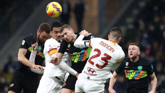 MILAN, ITALY - FEBRUARY 08: Edin Dzeko (C) of FC Internazionale competes for the ball with Chris Smalling (L) and Gianluca Mancini (R) of AS Roma during the Coppa Italia match between FC Internazionale and AS Roma at Stadio Giuseppe Meazza on February 08, 2022 in Milan, Italy. (Photo by Marco Luzzani/Getty Images)