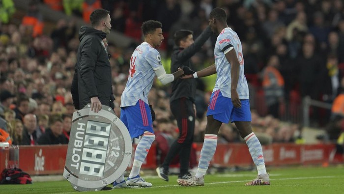 Manchester Uniteds Paul Pogba, right, is substituted by Manchester Uniteds Jesse Lindgard during the English Premier League soccer match between Liverpool and Manchester United at Anfield stadium in Liverpool, England, Tuesday, April 19, 2022. (AP Photo/Jon Super)