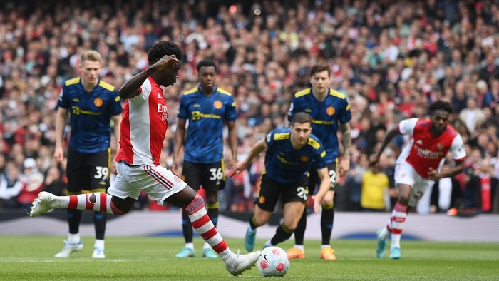 LONDON, ENGLAND - APRIL 23: Bukayo Saka of Arsenal scores their teams second goal from the penalty spot during the Premier League match between Arsenal and Manchester United at Emirates Stadium on April 23, 2022 in London, England. (Photo by Mike Hewitt/Getty Images)