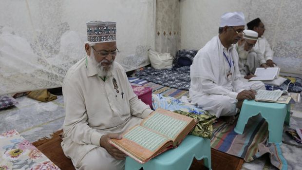 Muslim worshippers recites from the Quran in their section while they observe 