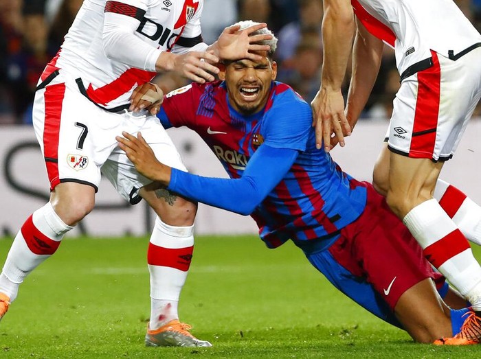 Barcelona's Ronald Araujo, centre, challenges for the ball during a Spanish La Liga soccer match between FC Barcelona and Rayo Vallecano at the Camp Nou stadium in Barcelona, Spain, Sunday, April 24, 2022. (AP Photo/Joan Monfort)