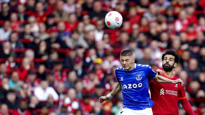 Bungkam Everton, Liverpool Tempel Ketat Man City di Puncak Klasemen Everton's Demarai Gray, left, challenges Liverpool's Andrew Robertson during the English Premier League soccer match between Liverpool and Everton at Anfield stadium in Liverpool, England, Sunday, April 24, 2022. (AP Photo/Jon Super)