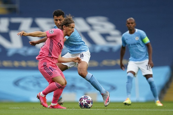 Real Madrids Croatian midfielder Luka Modric (front L) fights for the ball with Manchester Citys Spanish midfielder Rodri during the UEFA Champions League round of 16 second leg football match between Manchester City and Real Madrid at the Etihad Stadium in Manchester, north west England on August 7, 2020. (Photo by Dave Thompson / POOL / AFP)