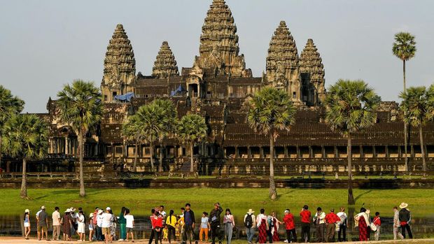 This picture taken on April 7, 2022 shows tourists visiting the Angkor Wat temple complex, a UNESCO World Heritage Site, in Siem Reap province. (Photo by TANG CHHIN Sothy / AFP) / TO GO WITH Cambodia-economy-tourism, FOCUS by Suy SE