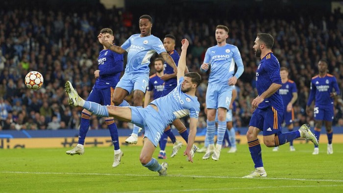Real Madrids Karim Benzema, right, celebrates after scoring his sides opening goal during the Champions League semi final, first leg soccer match between Manchester City and Real Madrid at the Etihad stadium in Manchester, England, Tuesday, April 26, 2022. (AP Photo/Jon Super)